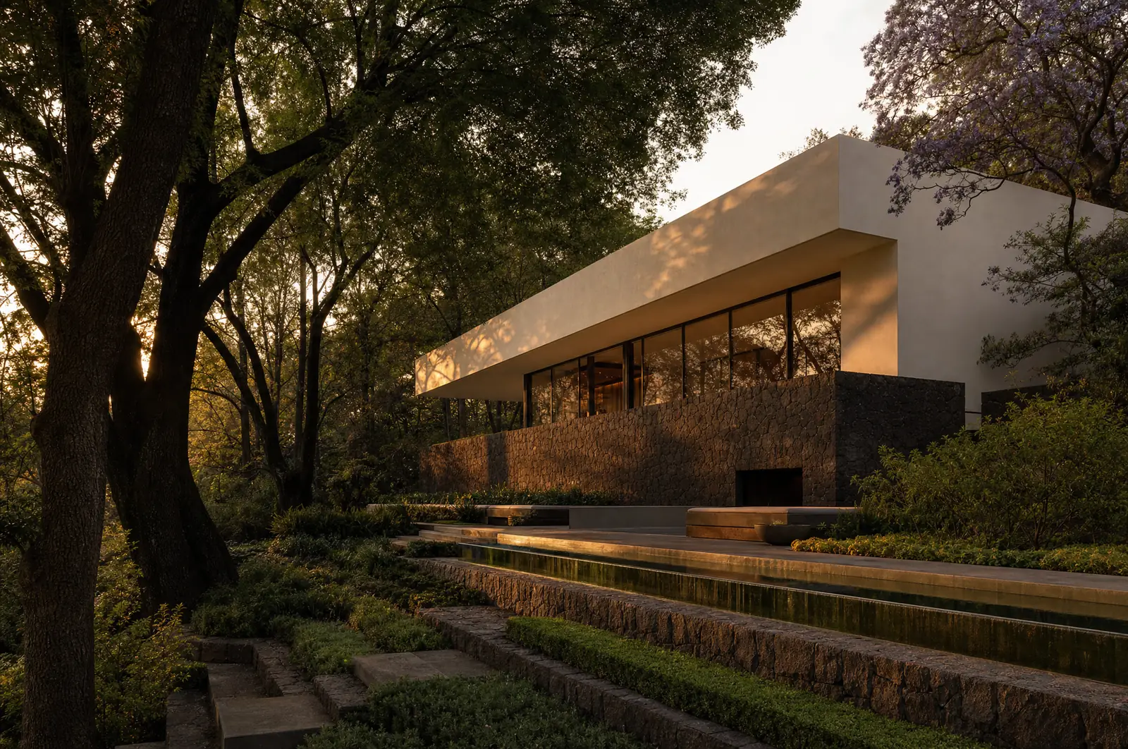 Residencia contemporanea en Lomas de Chapultepec vista desde el jardin en terrazas, basamento de piedra volcanica y volumen en voladizo a la luz del atardecer